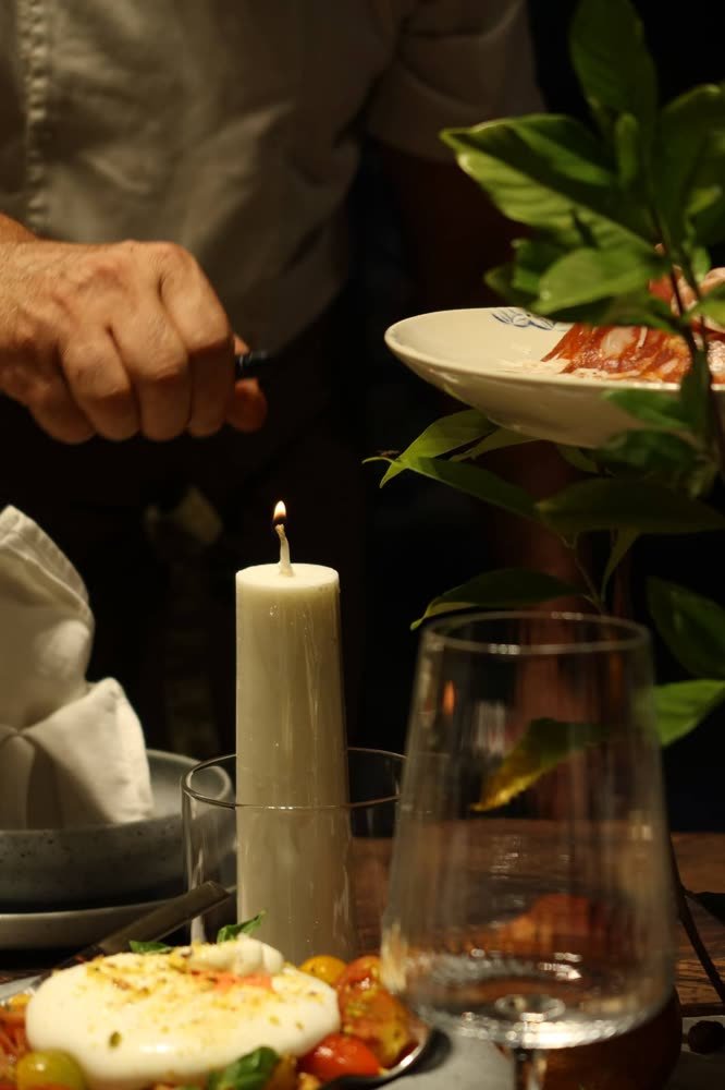 Lucio's hands plating behind a candle